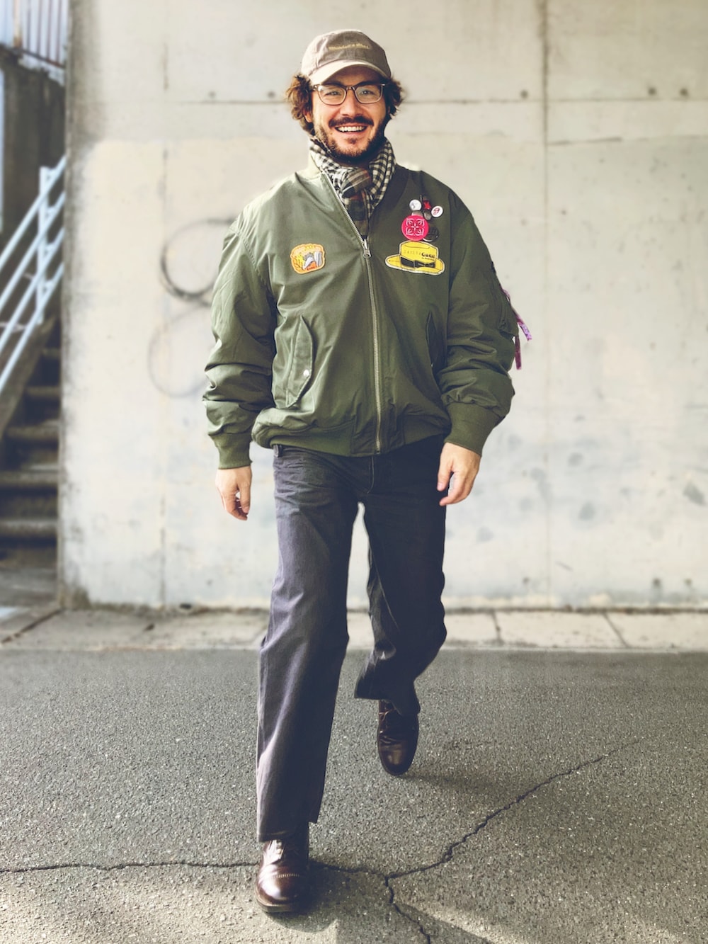 グリーン系のMA-1、ホワイト系のTシャツ/カットソー、グレー系のスラックスを着用したメンズの冬コーディネートの3枚目の写真