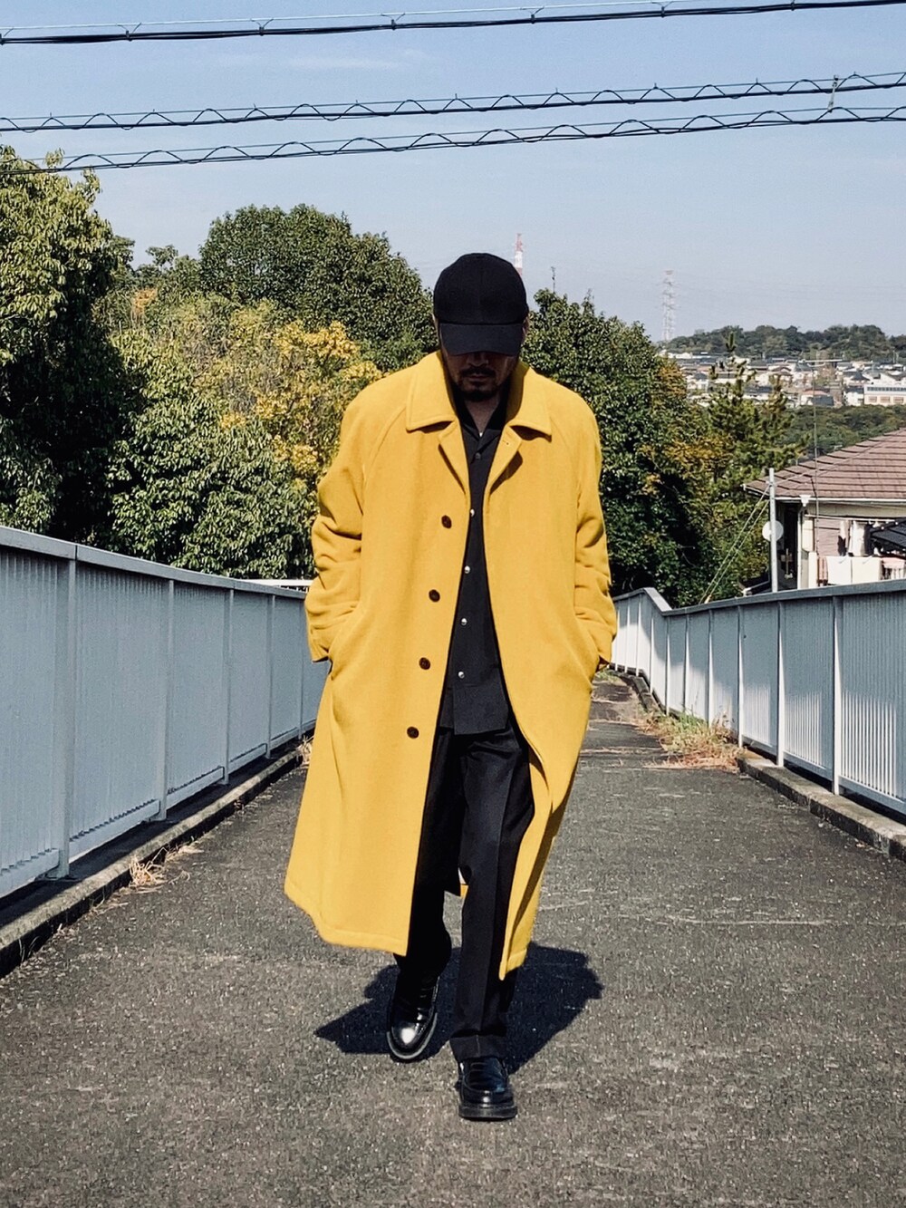 ブラック系のシャツ/ブラウス、イエロー系のステンカラーコート、ブラック系のその他パンツを着用したメンズの秋コーディネートの3枚目の写真