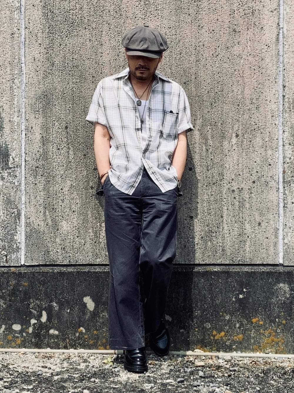 ホワイト系のタンクトップ、グリーン系のシャツ/ブラウス、グレー系のスラックスを着用したメンズの夏コーディネートの2枚目の写真