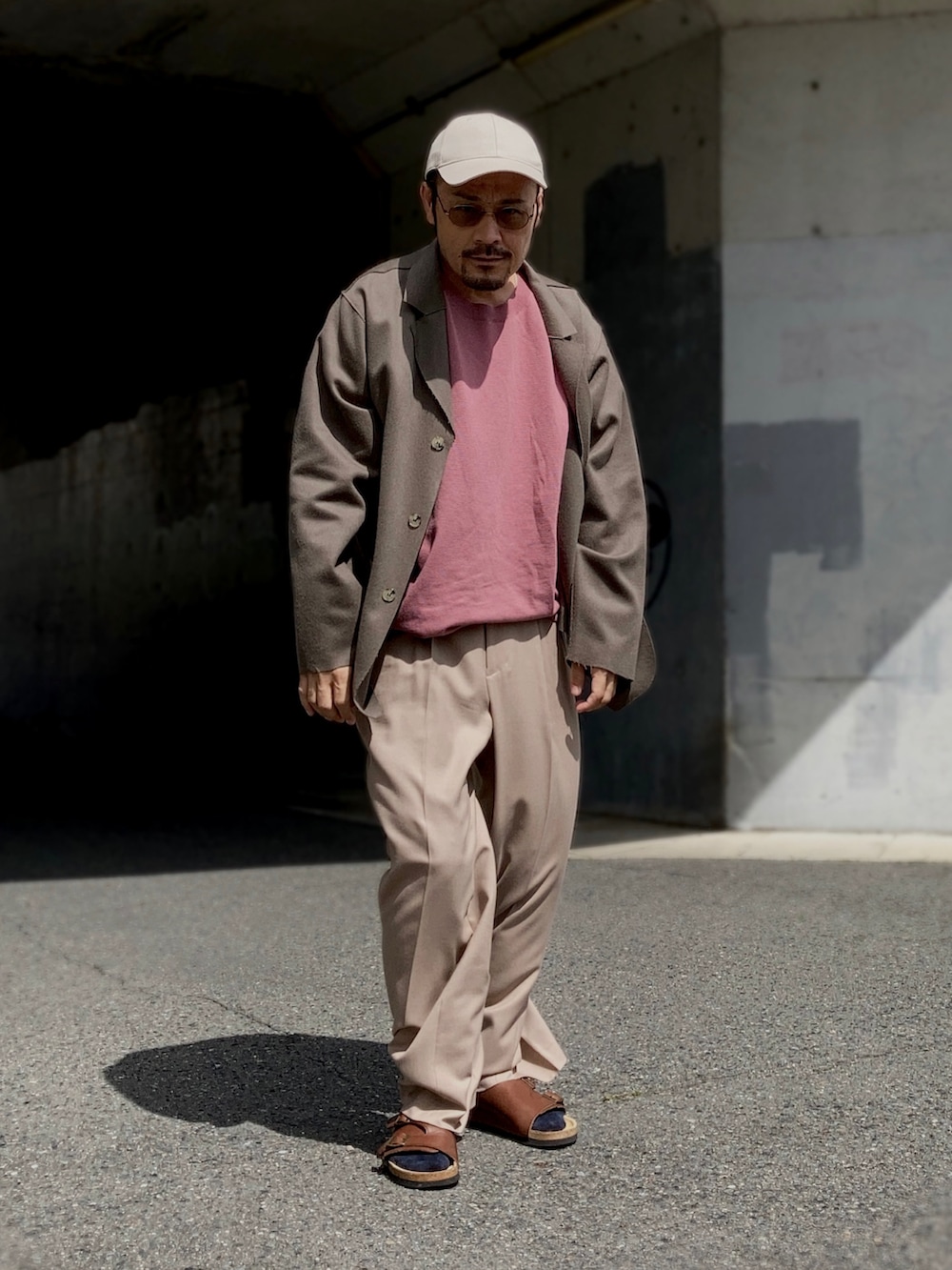 ピンク系のTシャツ/カットソー、ブラウン系のテーラードジャケット、ベージュ系のスラックスを着用したメンズの秋コーディネートの2枚目の写真