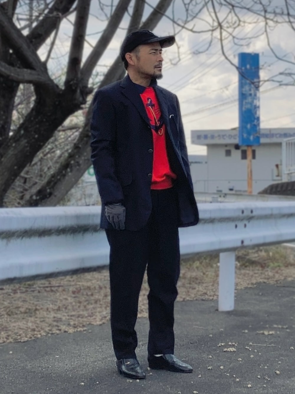 レッド系のスウェット、ブルー系のテーラードジャケット、ブラック系のスラックスを着用したメンズの春コーディネートの2枚目の写真