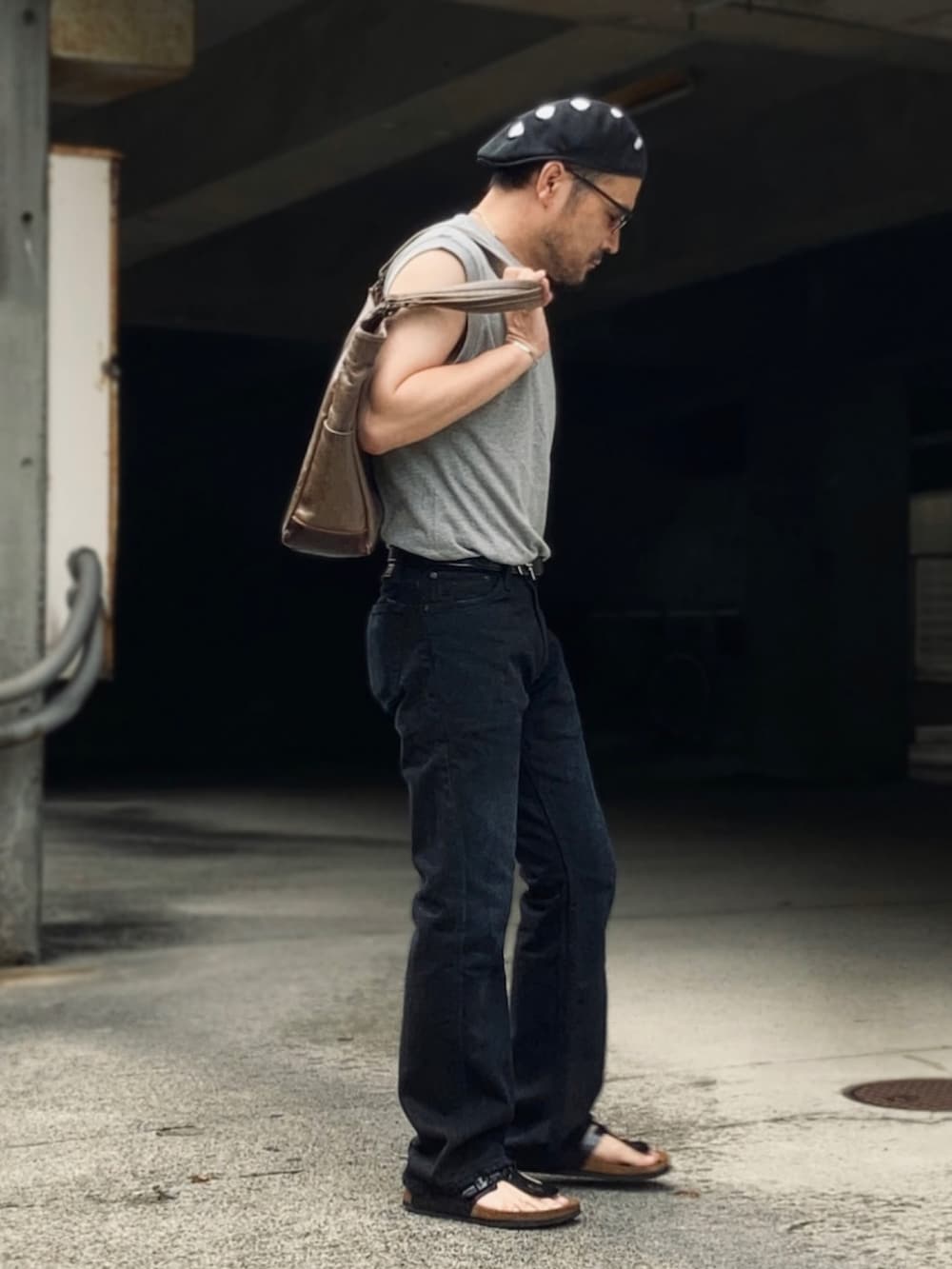 グレー系のTシャツ/カットソー、ブラック系のデニムパンツ、ブラック系のサンダルを着用したメンズの夏コーディネートの3枚目の写真