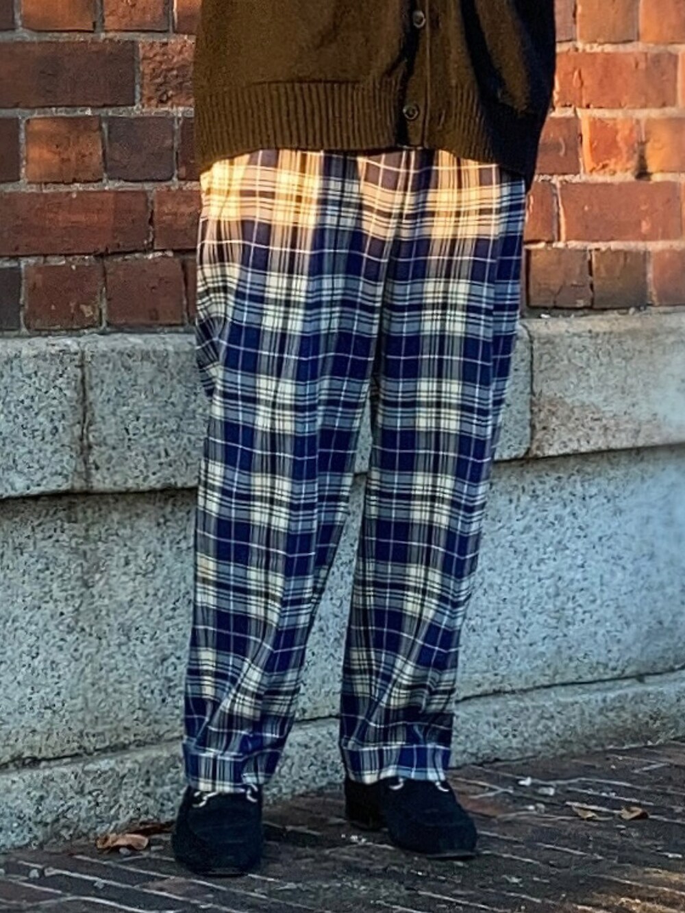 ブラック系のタンクトップ、ブラック系のカーディガン/ボレロ、ブルー系のスラックスを着用したメンズの秋コーディネートの4枚目の写真