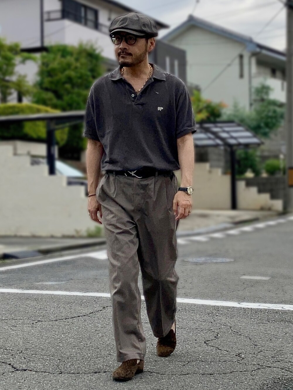 グレー系のポロシャツ、グレー系のスラックス、ブラウン系のスリッポンを着用したメンズの夏コーディネートの3枚目の写真