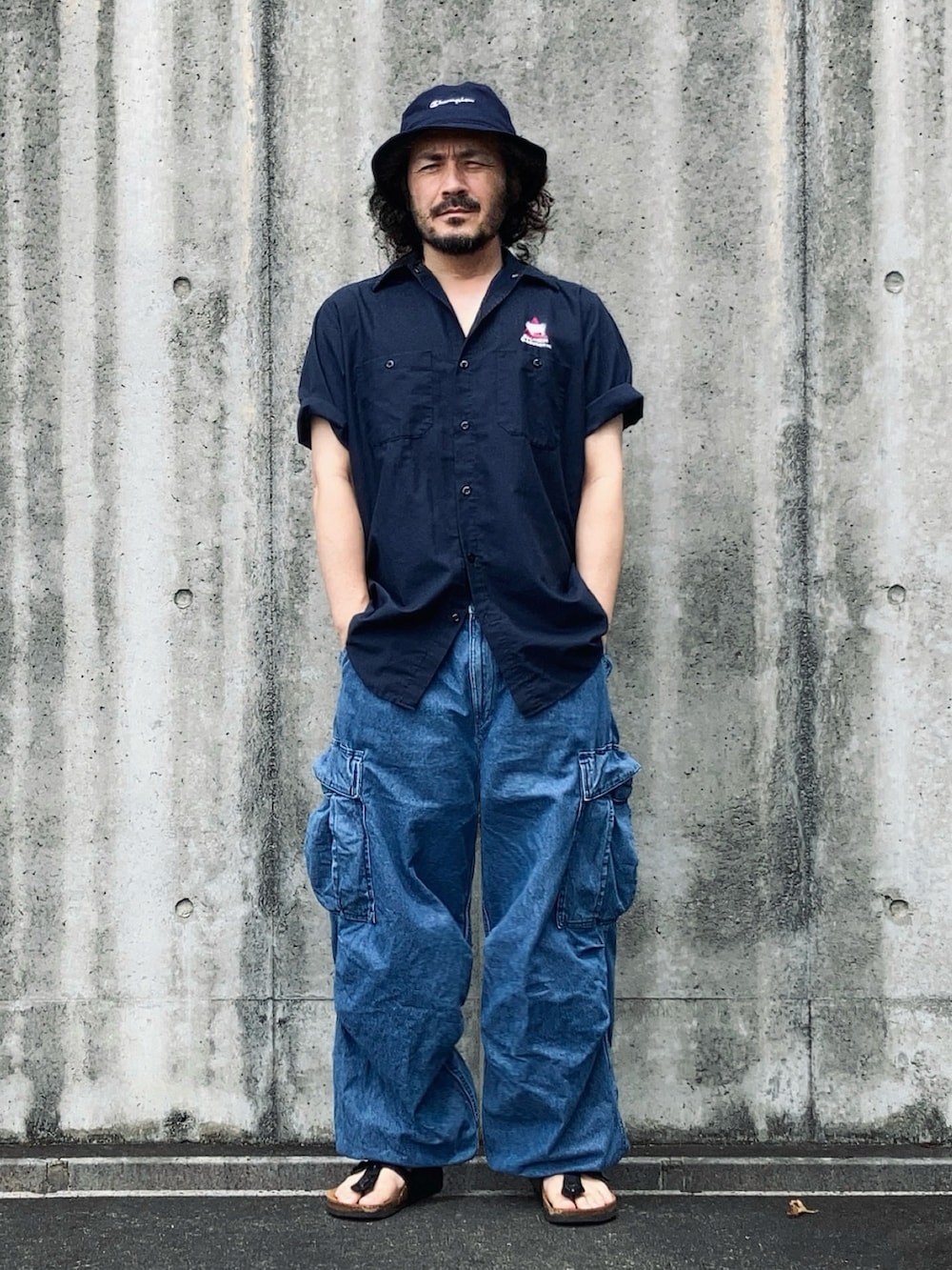 ブルー系のシャツ/ブラウス、ブルー系のカーゴパンツ、ブラック系のサンダルを着用したメンズの夏コーディネートの4枚目の写真