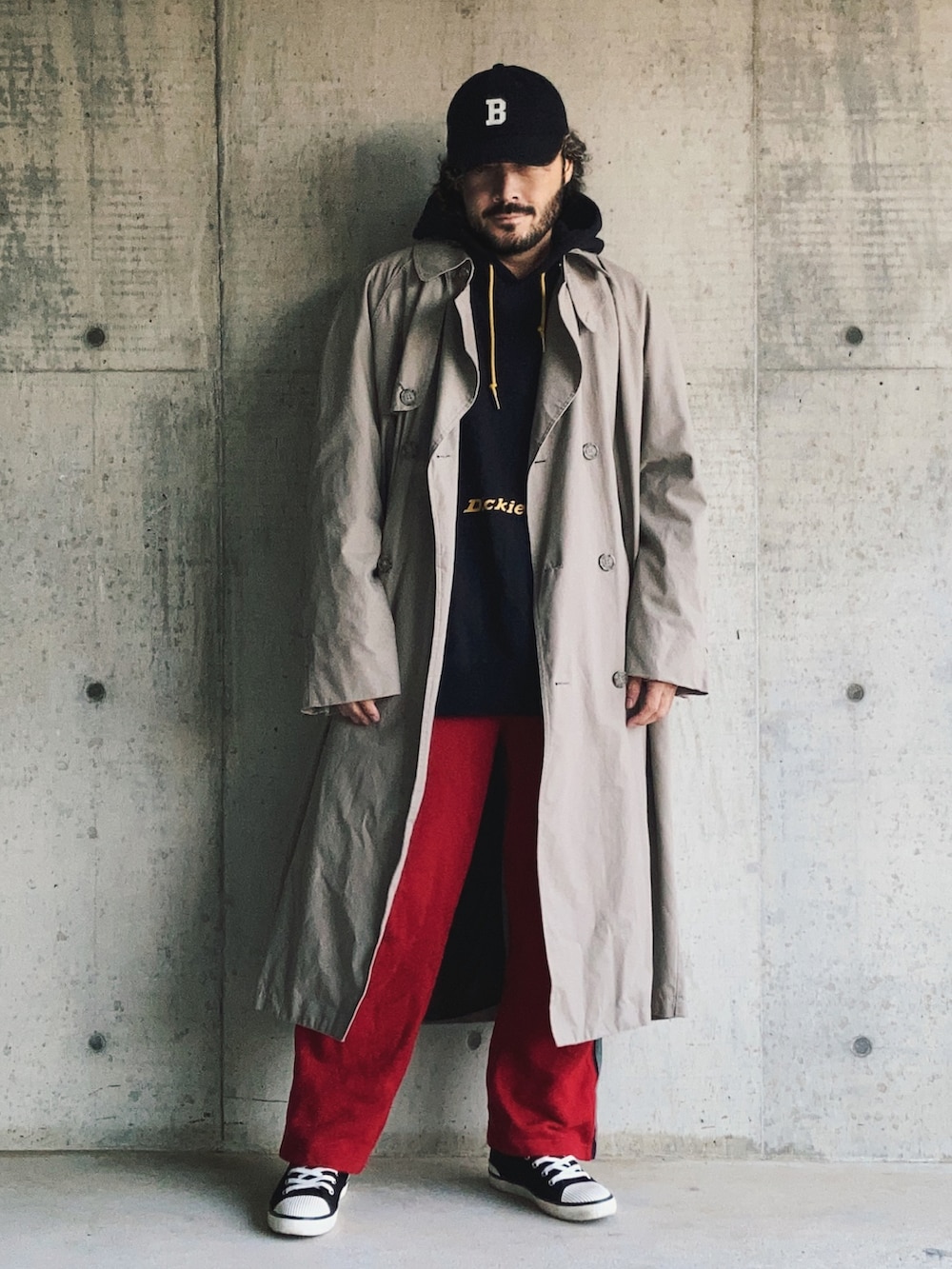 ブラック系のパーカー、ベージュ系のトレンチコート、レッド系のスウェットパンツを着用したメンズの秋コーディネートの2枚目の写真