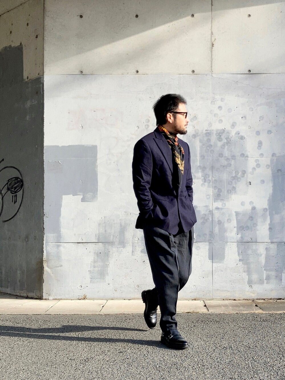 ブラウン系のニット/セーター、ブルー系のテーラードジャケット、グレー系のスラックスを着用したメンズの冬コーディネートの3枚目の写真