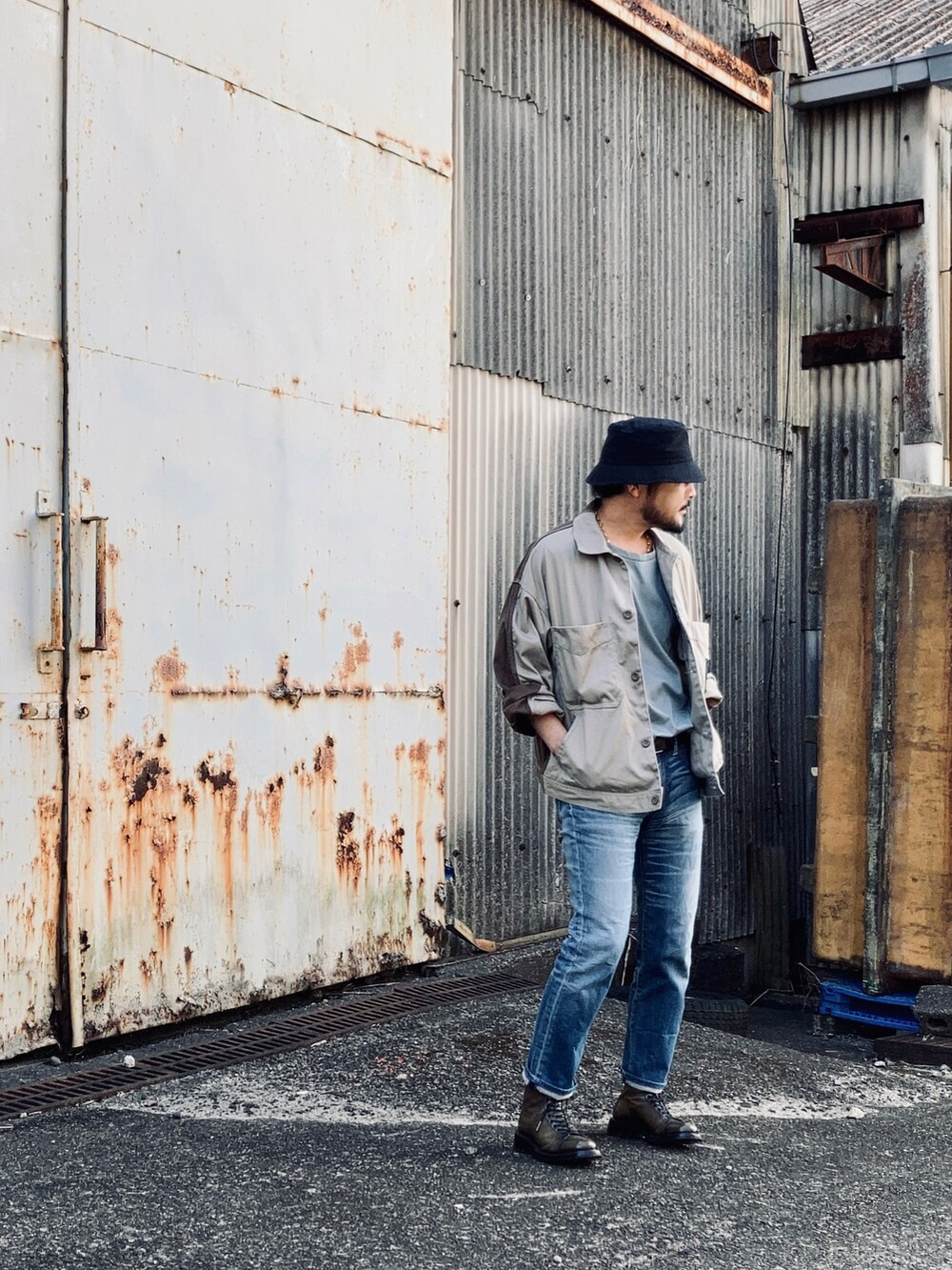 グリーン系のTシャツ/カットソー、ベージュ系のその他アウター、ブルー系のデニムパンツを着用したメンズの春コーディネートの5枚目の写真