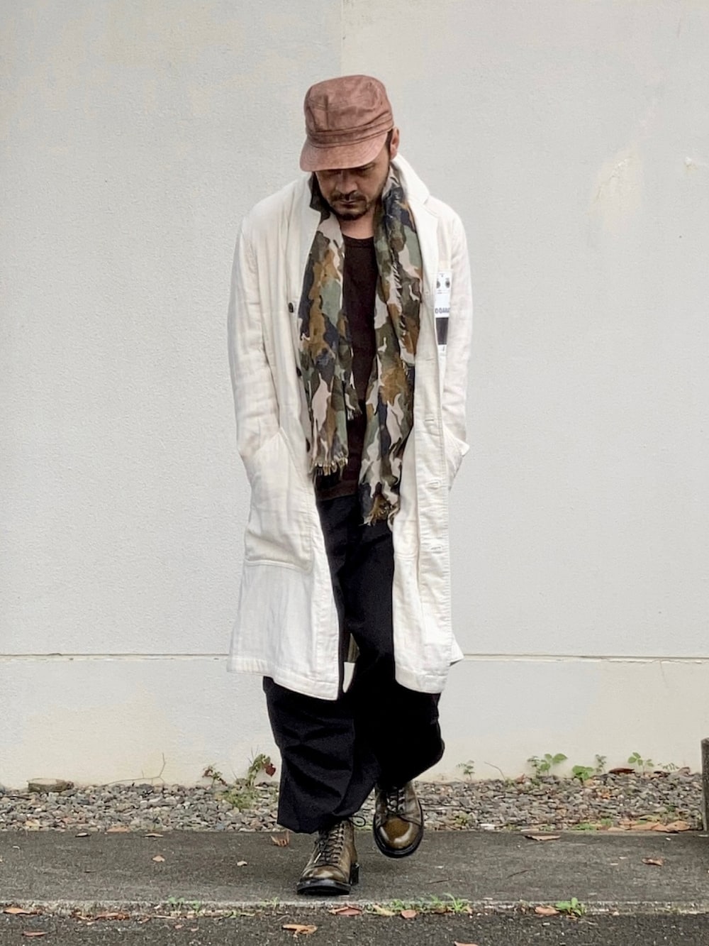 ブラウン系のタンクトップ、ホワイト系のダウンジャケット/コート、ブラック系のカーゴパンツを着用したメンズの秋コーディネートの4枚目の写真