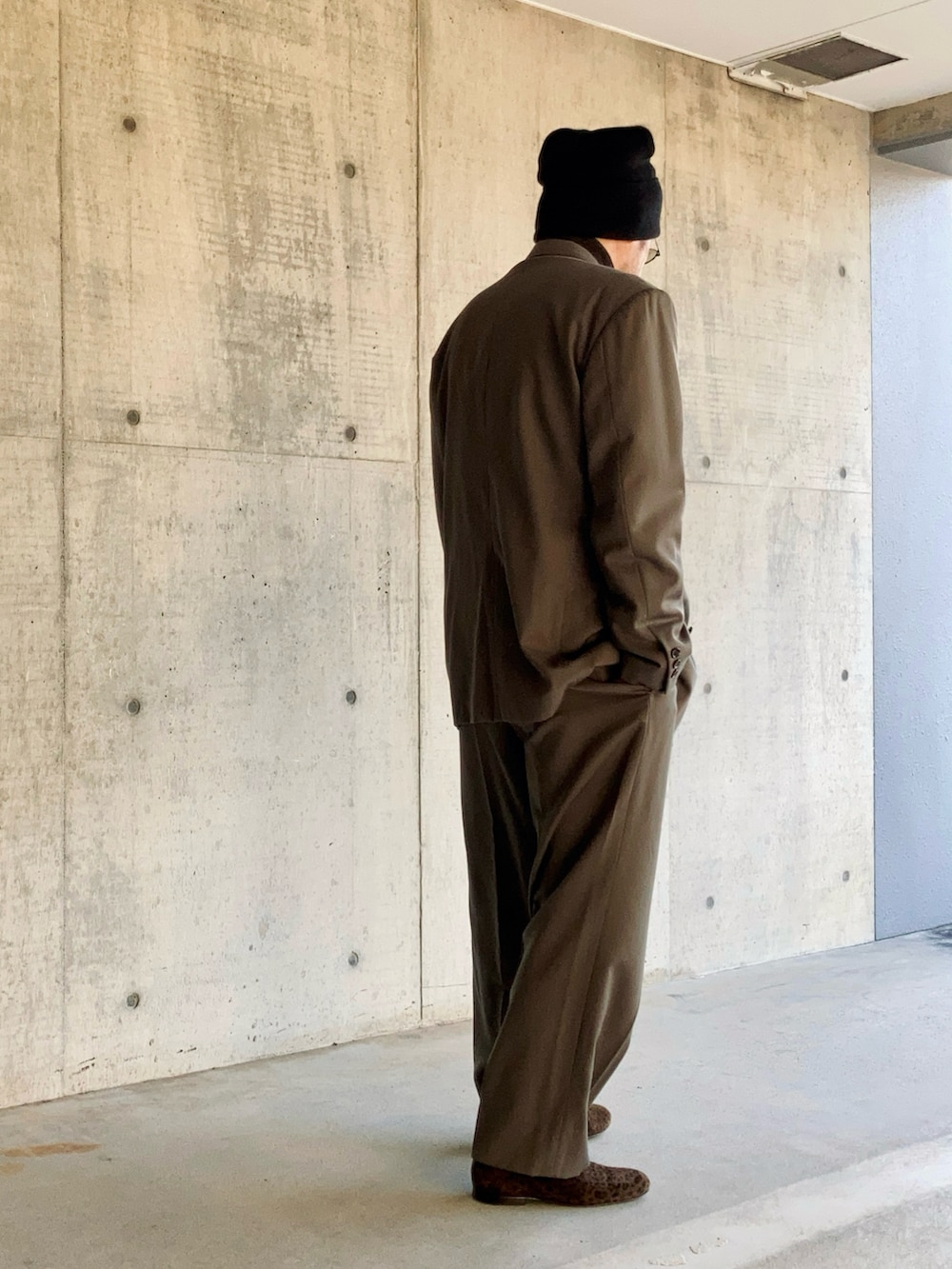 グレー系のスーツジャケット、グレー系のスーツパンツ、ブラウン系のスリッポンを着用したメンズの冬コーディネートの3枚目の写真