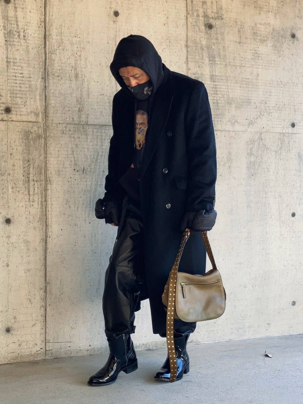 ブラック系のパーカー、ブラック系のチェスターコート、ブラック系のその他パンツを着用したメンズの冬コーディネートの3枚目の写真