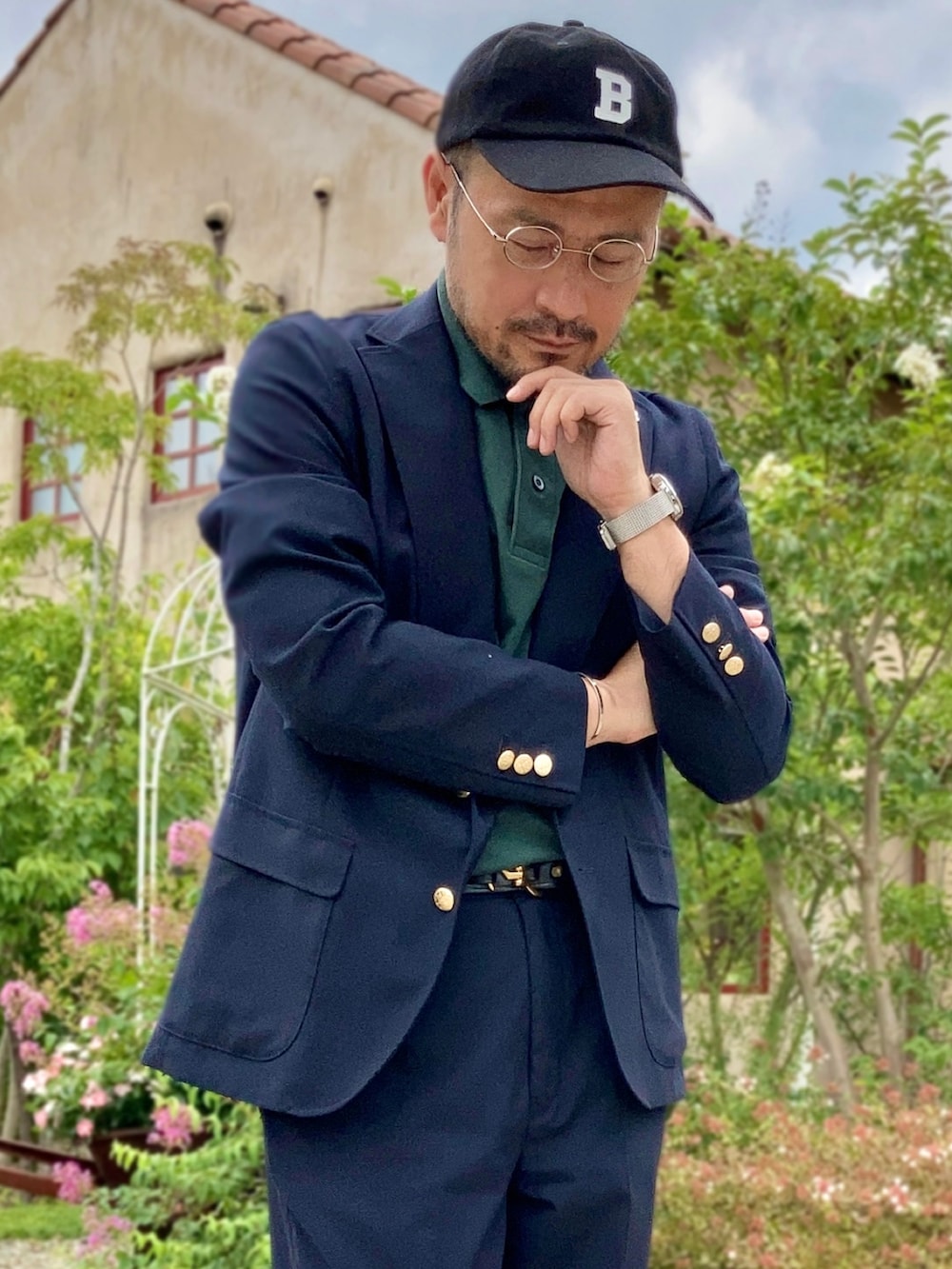 グリーン系のポロシャツ、ブルー系のテーラードジャケット、ブルー系のスラックスを着用したメンズの夏コーディネートの3枚目の写真