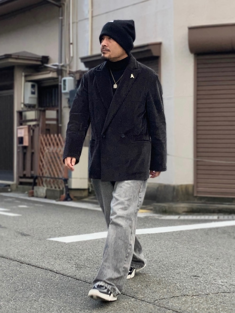 ブラック系のニット/セーター、グレー系のテーラードジャケット、グレー系のデニムパンツを着用したメンズの冬コーディネートの3枚目の写真