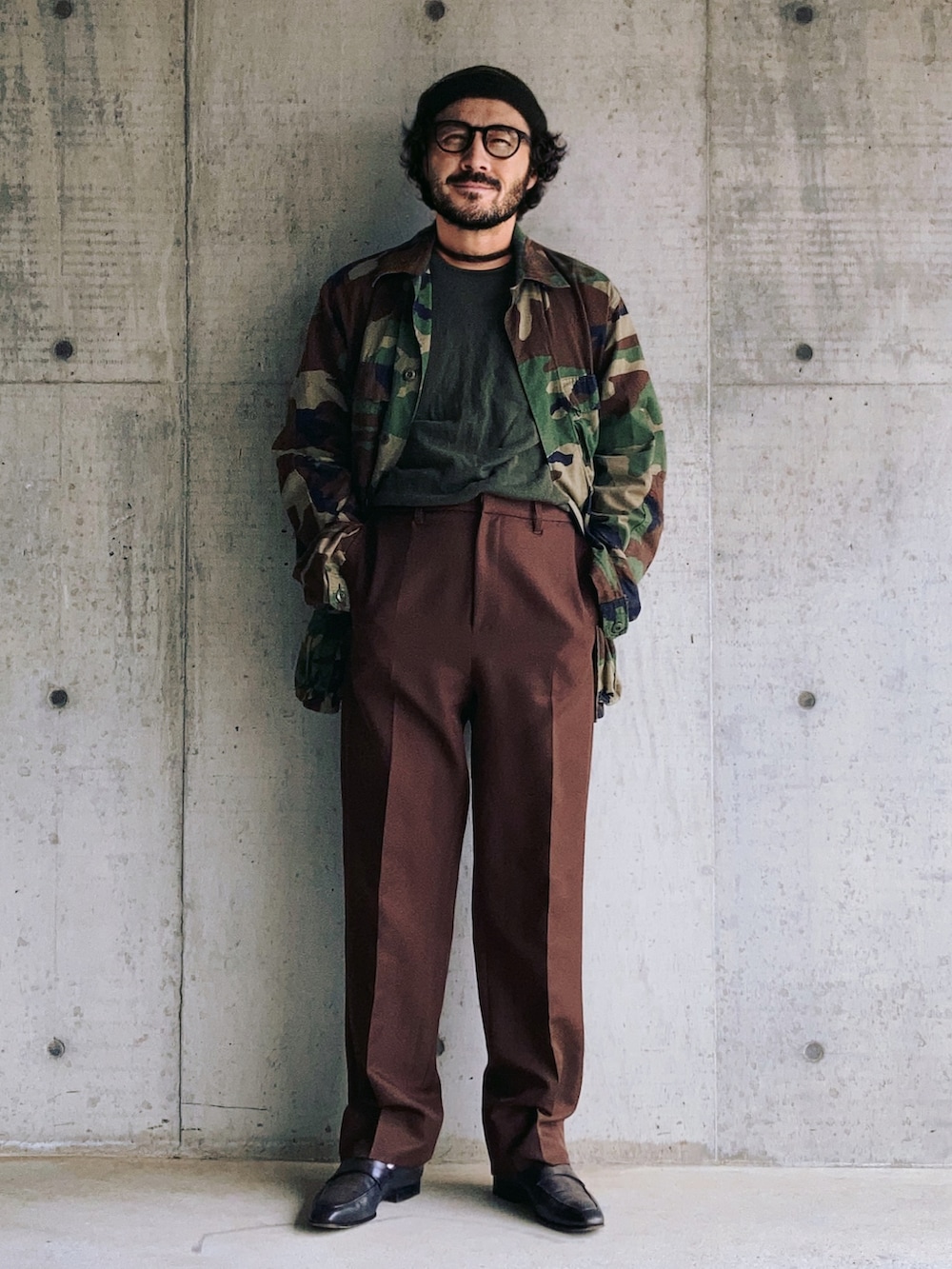 その他のミリタリージャケット、ブラウン系のスラックス、グリーン系のローファーを着用したメンズの春コーディネートの2枚目の写真