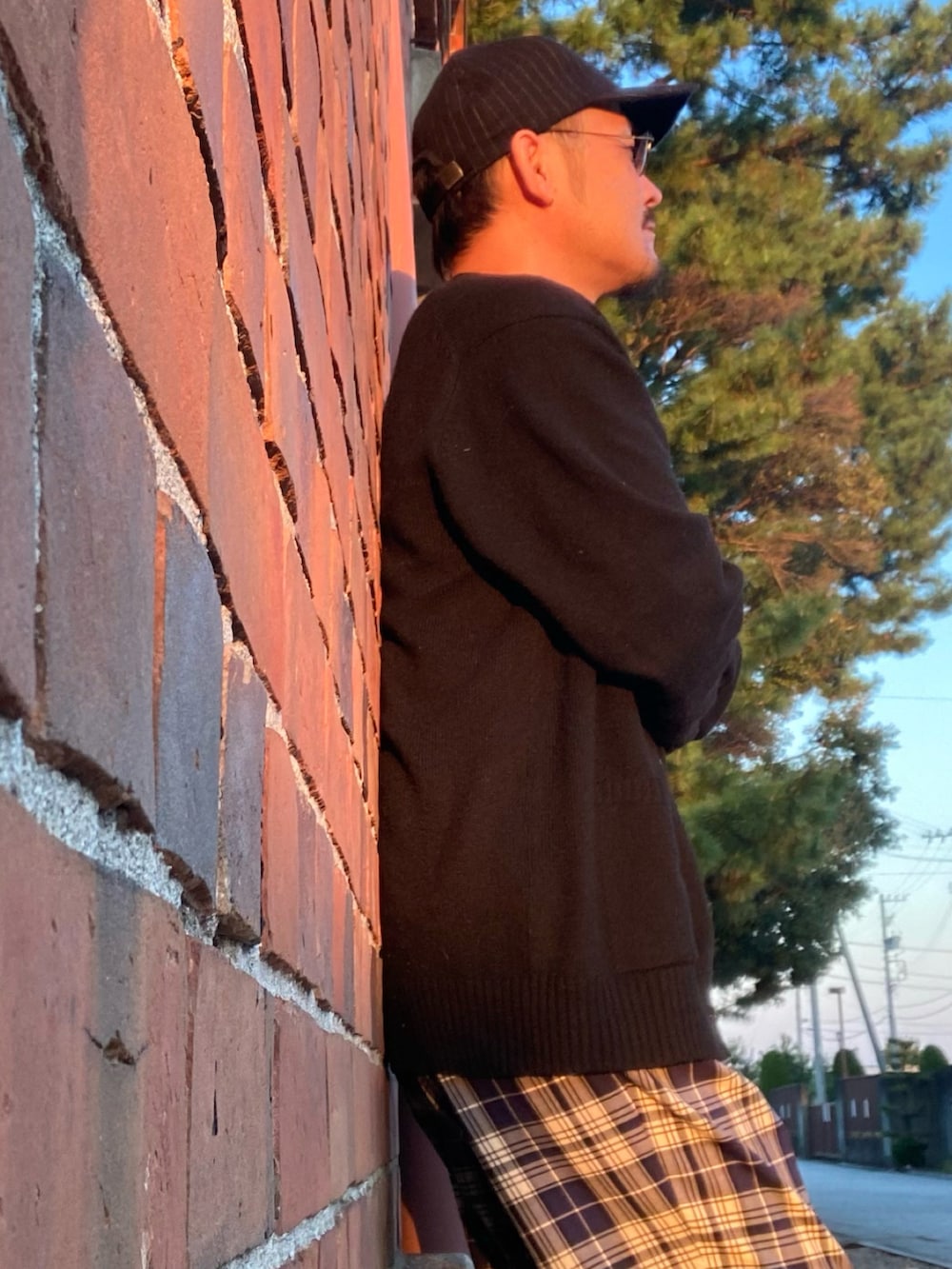 ブラック系のタンクトップ、ブラック系のカーディガン/ボレロ、ブルー系のスラックスを着用したメンズの秋コーディネートの3枚目の写真