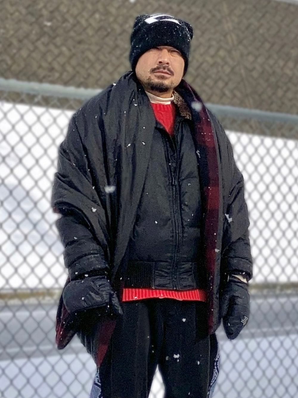 ベージュ系のTシャツ/カットソー、レッド系のニット/セーター、ブラック系のダウンジャケット/コートを着用したメンズの冬コーディネートの5枚目の写真