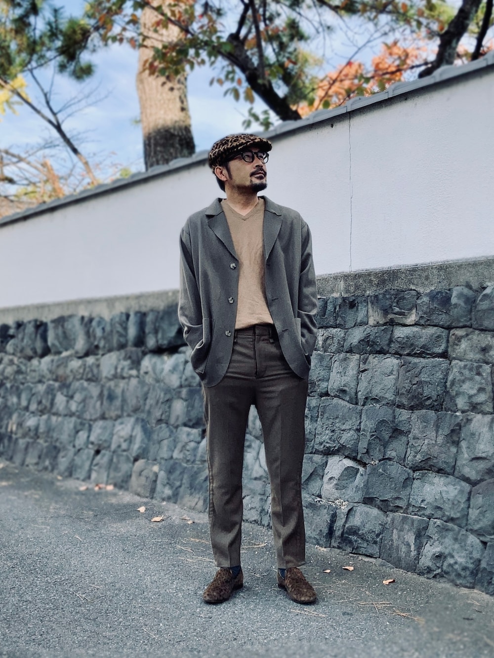 ブラウン系のニット/セーター、ブラウン系のテーラードジャケット、グリーン系のスラックスを着用したメンズの秋コーディネートの5枚目の写真