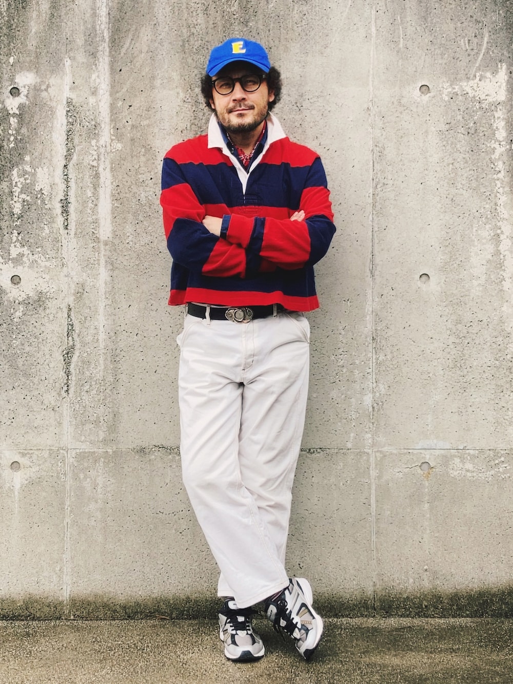 レッド系のポロシャツ、ホワイト系のデニムパンツ、ブラック系のスニーカーを着用したメンズの冬コーディネートの2枚目の写真