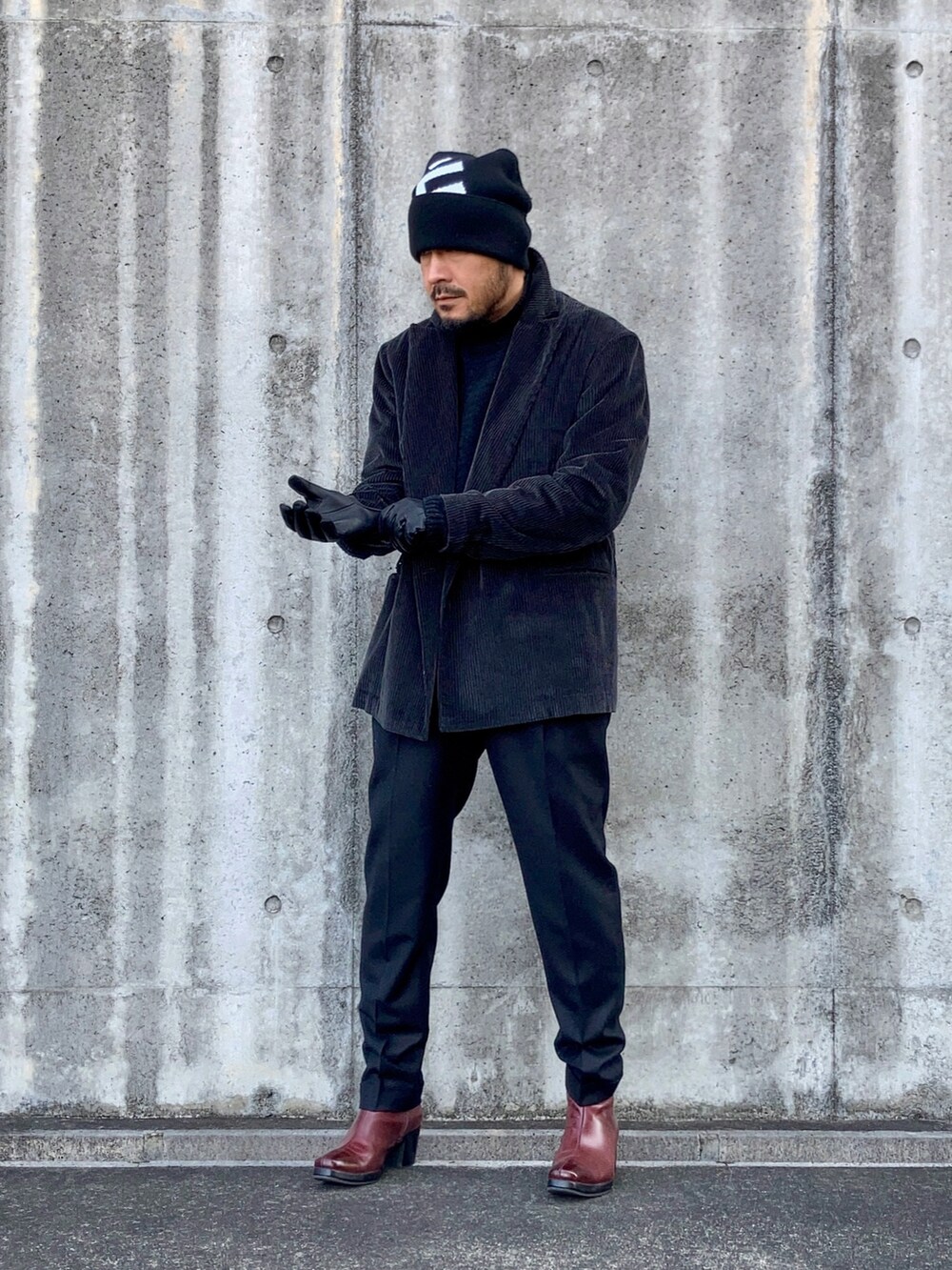 ブラック系のニット/セーター、グレー系のテーラードジャケット、ブラック系のその他パンツを着用したメンズの冬コーディネートの2枚目の写真