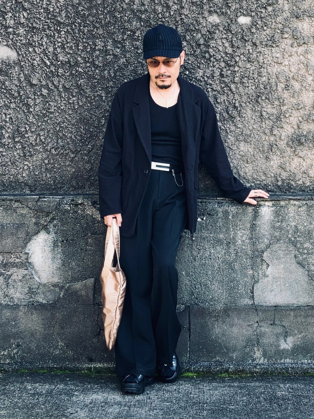 ブラック系のタンクトップ、ブラック系のテーラードジャケット、ブラック系のスラックスを着用したメンズの秋コーディネートの3枚目の写真