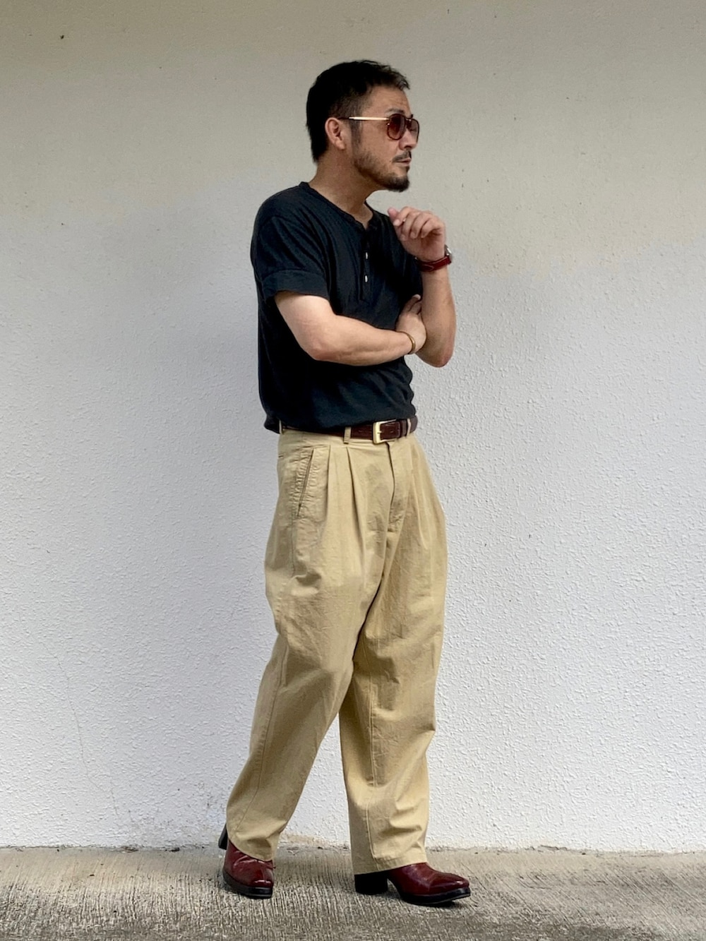 ブラック系のTシャツ/カットソー、ベージュ系のスラックス、レッド系のブーツを着用したメンズの秋コーディネートの3枚目の写真