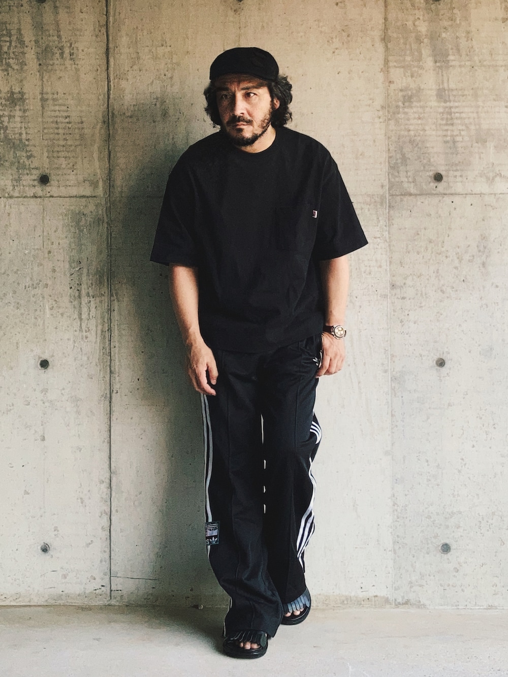 ブラック系のスウェットパンツ、ブラック系のTシャツ/カットソー、ブラック系のサンダルを着用したメンズの夏コーディネートの4枚目の写真