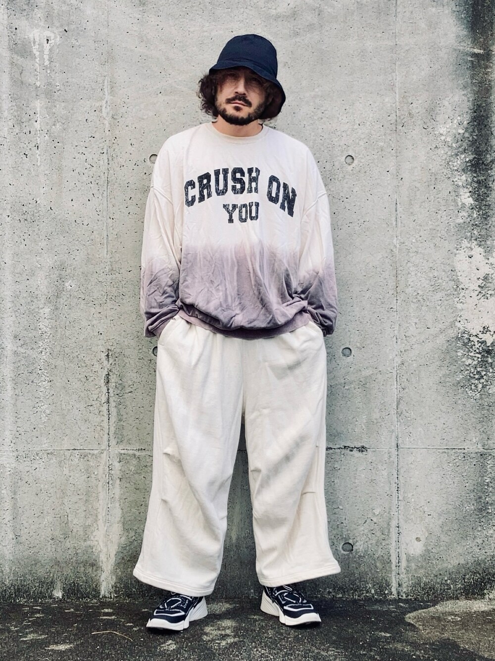 グレー系のスウェットパンツ、パープル系のスウェット、ブラック系のスニーカーを着用したメンズの秋コーディネートの2枚目の写真