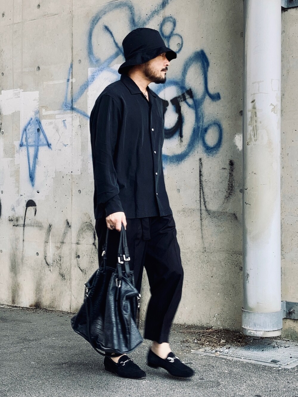 ブラック系のシャツ/ブラウス、ブラック系のスラックス、ブラック系のローファーを着用したメンズの春コーディネートの3枚目の写真