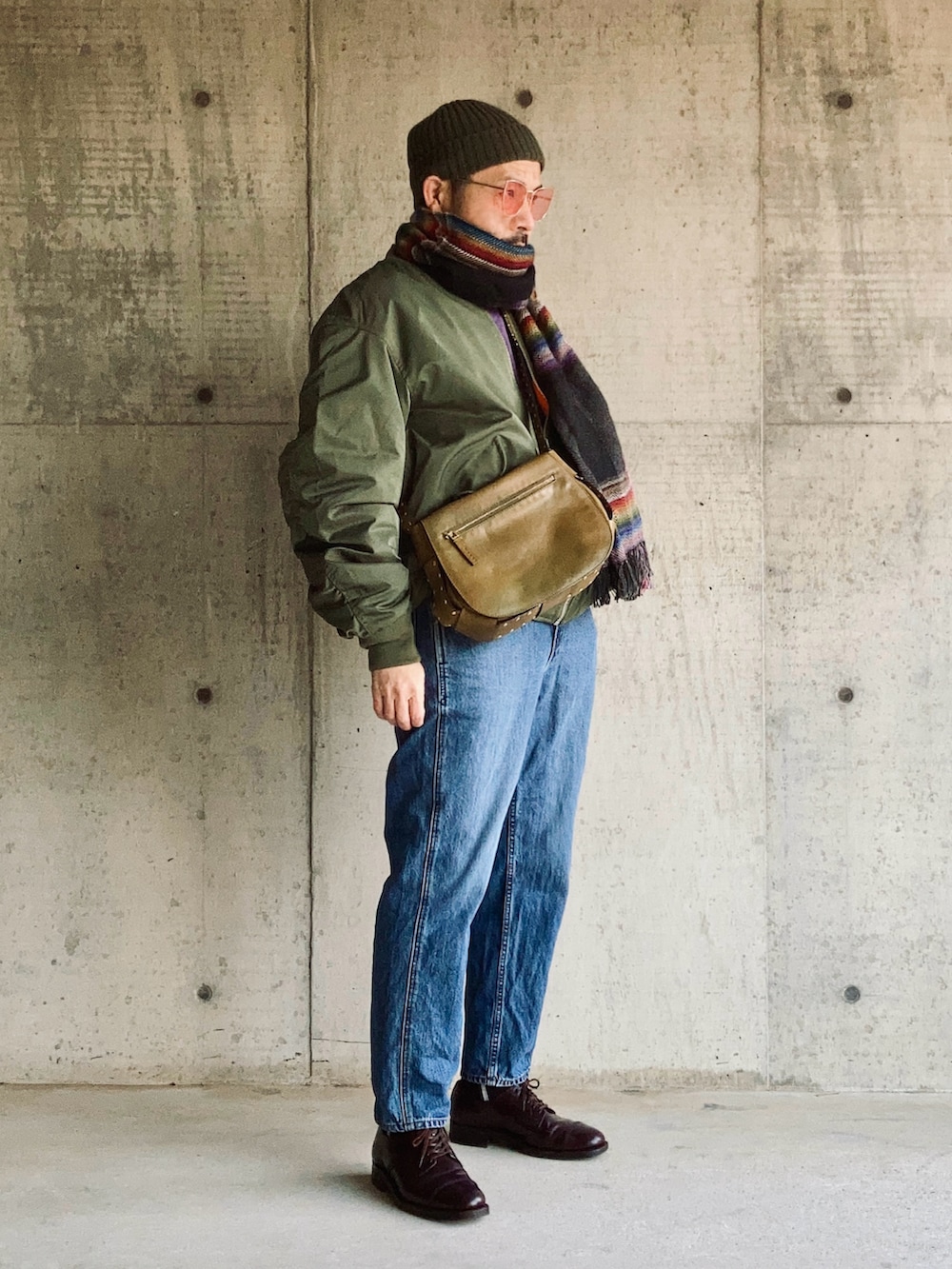 パープル系のスウェット、グリーン系のMA-1、ブルー系のデニムパンツを着用したメンズの冬コーディネートの4枚目の写真