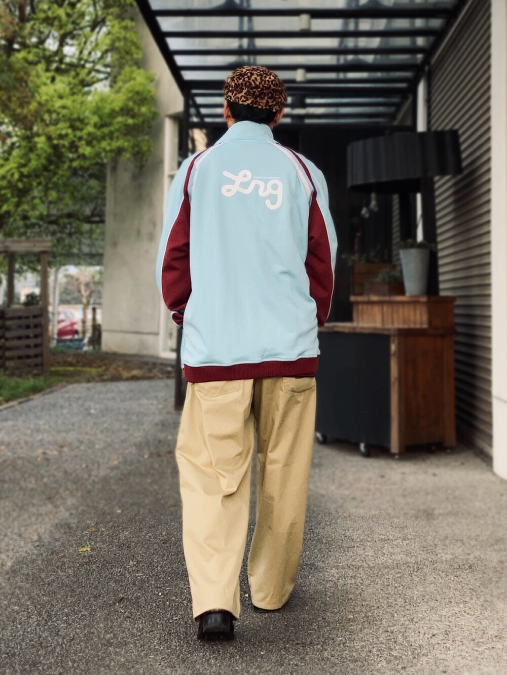 ベージュ系のチノパンツ、レッド系のポロシャツ、ブルー系のその他アウターを着用したメンズの春コーディネートの4枚目の写真