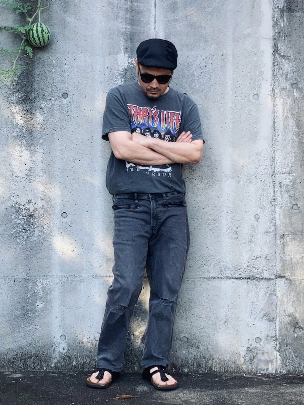 グレー系のTシャツ/カットソー、グレー系のデニムパンツ、ブラック系のサンダルを着用したメンズの夏コーディネートの2枚目の写真