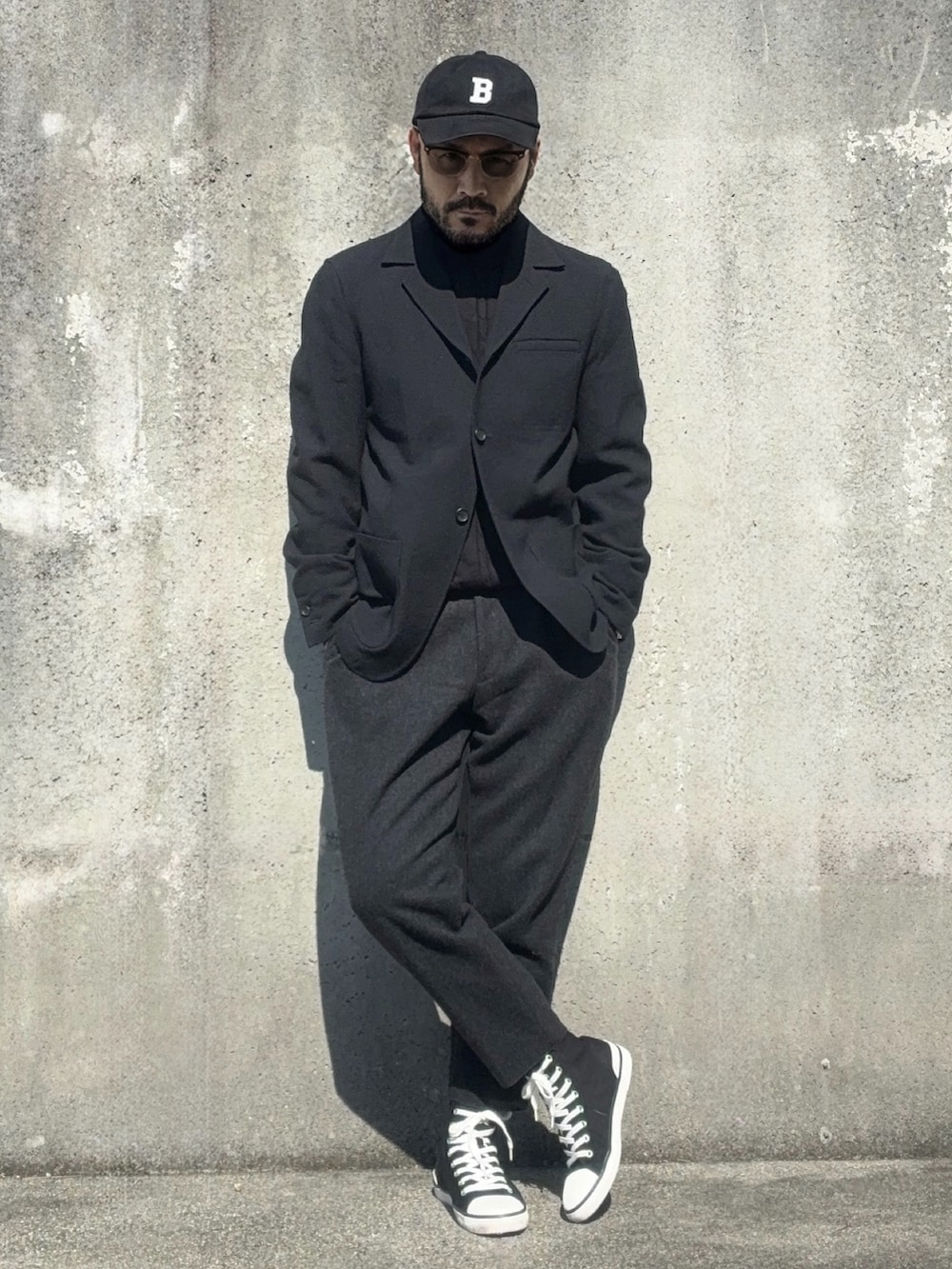 ブラック系のスニーカー、ブラック系のテーラードジャケット、ブラック系のスラックスを着用したメンズの春コーディネートの3枚目の写真