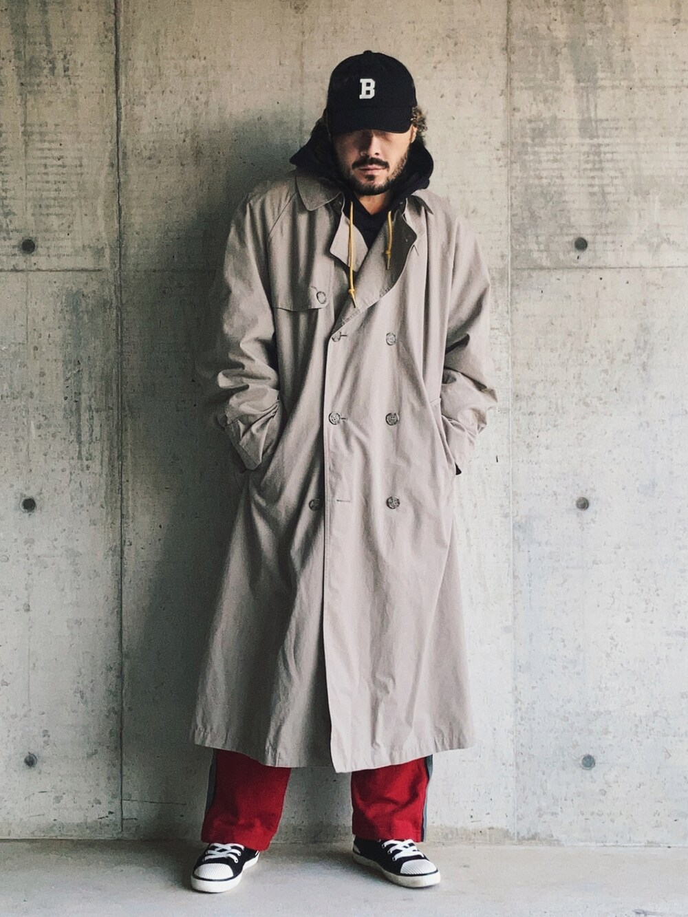 ブラック系のパーカー、ベージュ系のトレンチコート、レッド系のスウェットパンツを着用したメンズの秋コーディネートの3枚目の写真