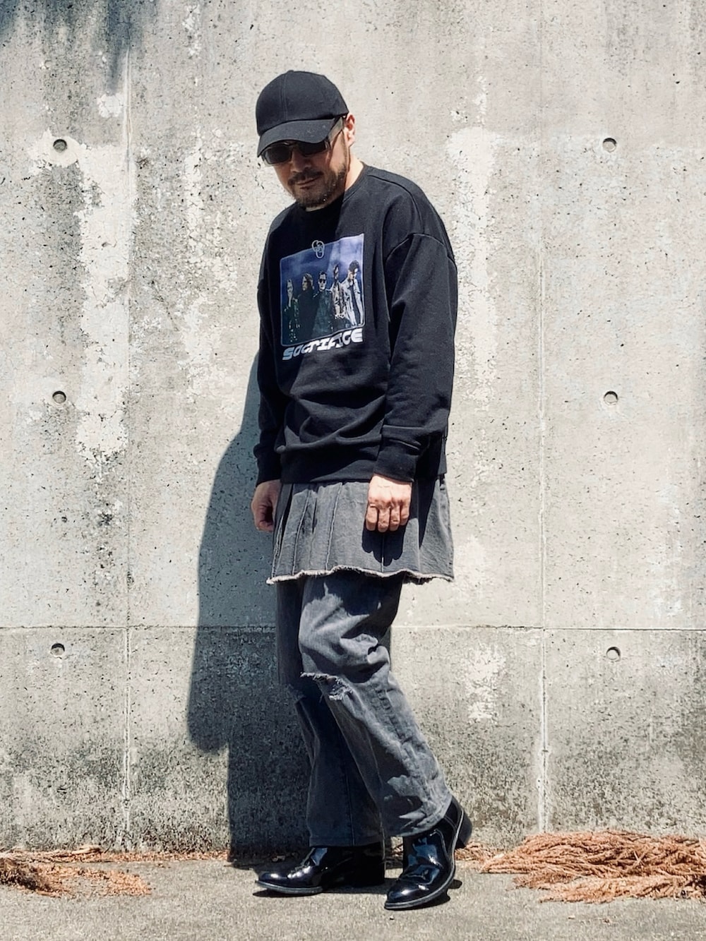 ブラック系のスウェット、グレー系のデニムパンツ、ブラック系のブーツを着用したメンズの春コーディネートの2枚目の写真