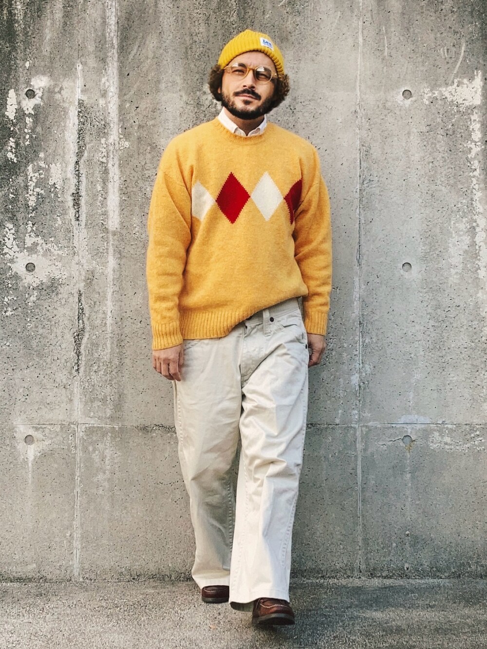 イエロー系のニット/セーター、ホワイト系のデニムパンツ、ブラウン系のモカシン/デッキシューズを着用したメンズの冬コーディネートの3枚目の写真