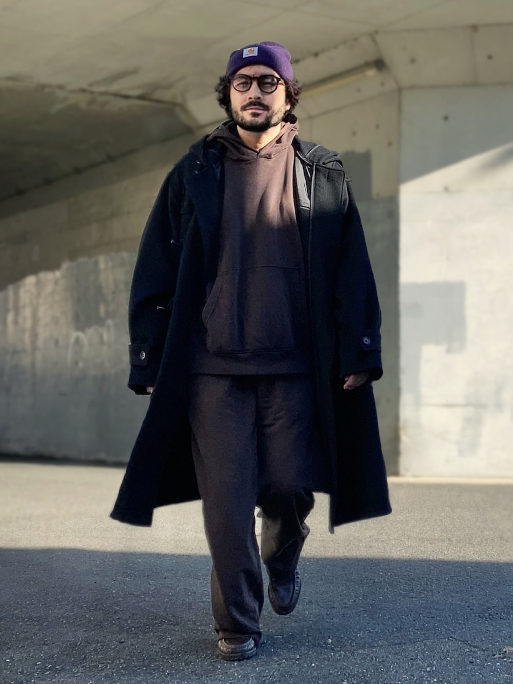 ブラウン系のパーカー、ブラウン系のスウェットパンツ、ブラック系のダッフルコートを着用したメンズの冬コーディネートの2枚目の写真