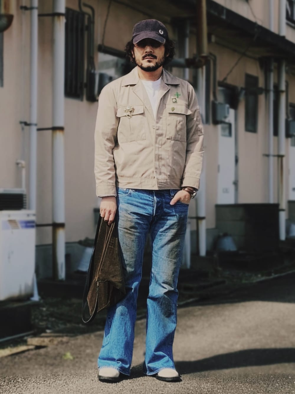 ブルー系のデニムパンツ、ホワイト系のTシャツ/カットソー、ベージュ系のその他アウターを着用したメンズの春コーディネートの2枚目の写真