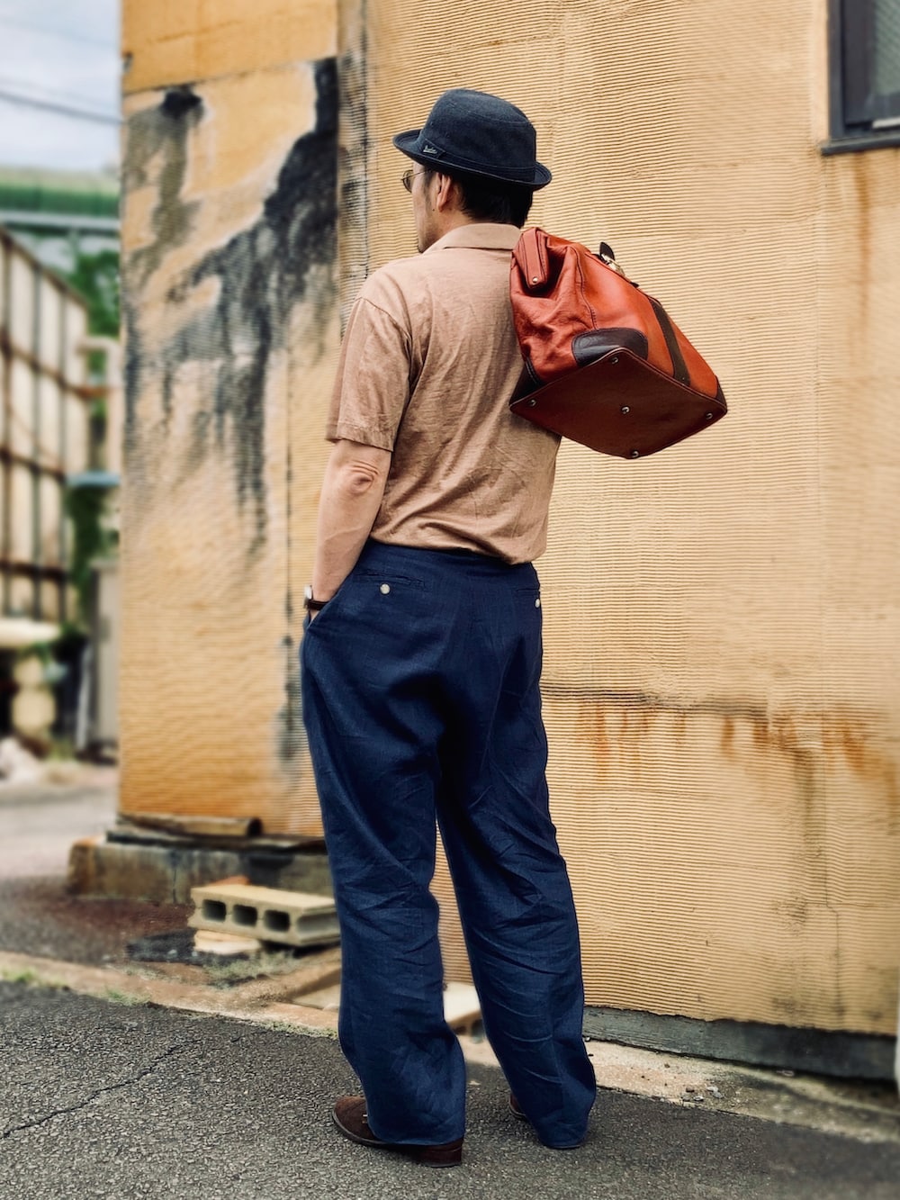 ブラウン系のポロシャツ、ブラウン系のドレスシューズ、ブラウン系のボストンバッグを着用したメンズの夏コーディネートの4枚目の写真