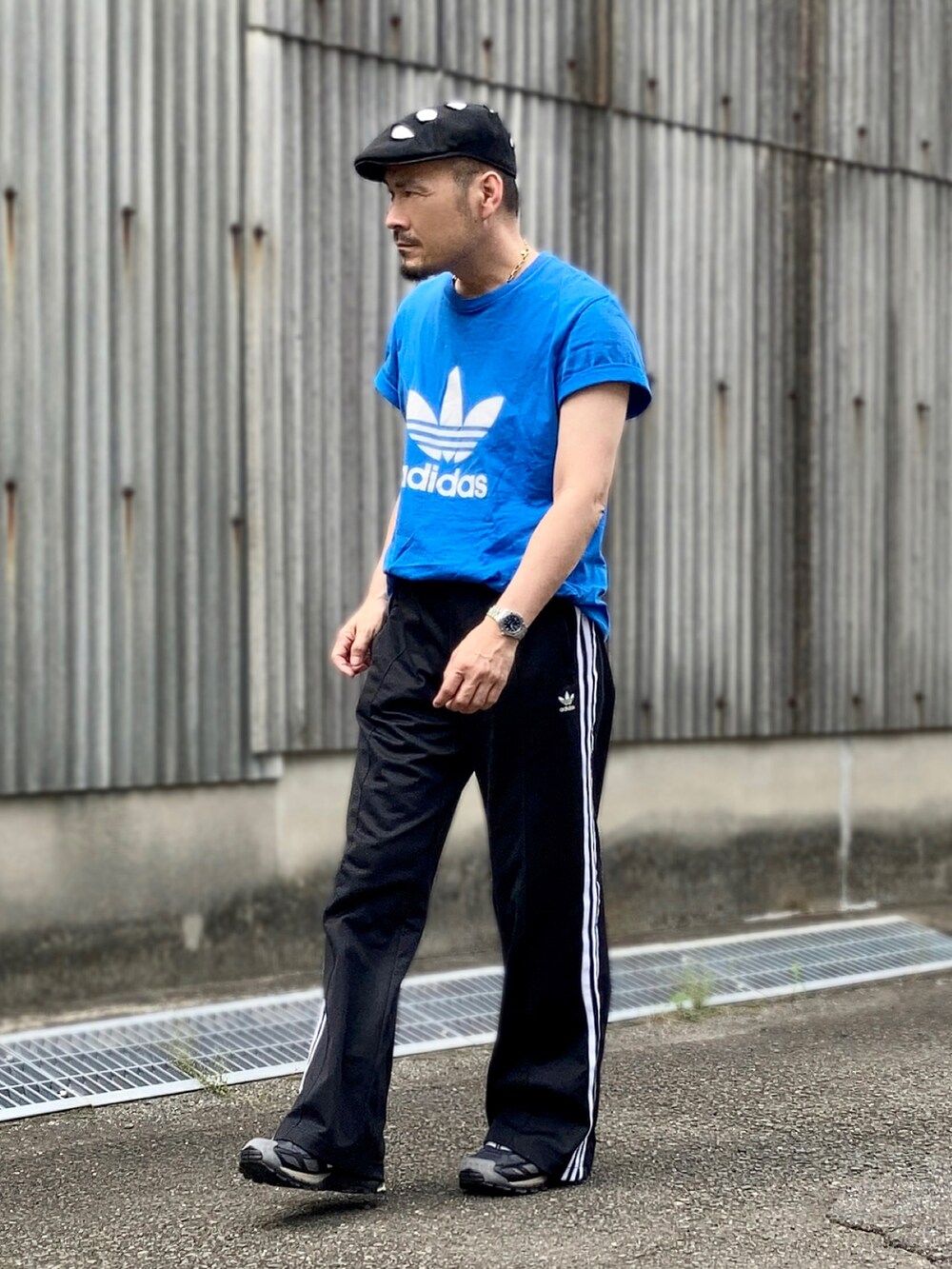 ブルー系のTシャツ/カットソー、ブラック系のスウェットパンツ、ブラック系のスニーカーを着用したメンズの夏コーディネートの2枚目の写真