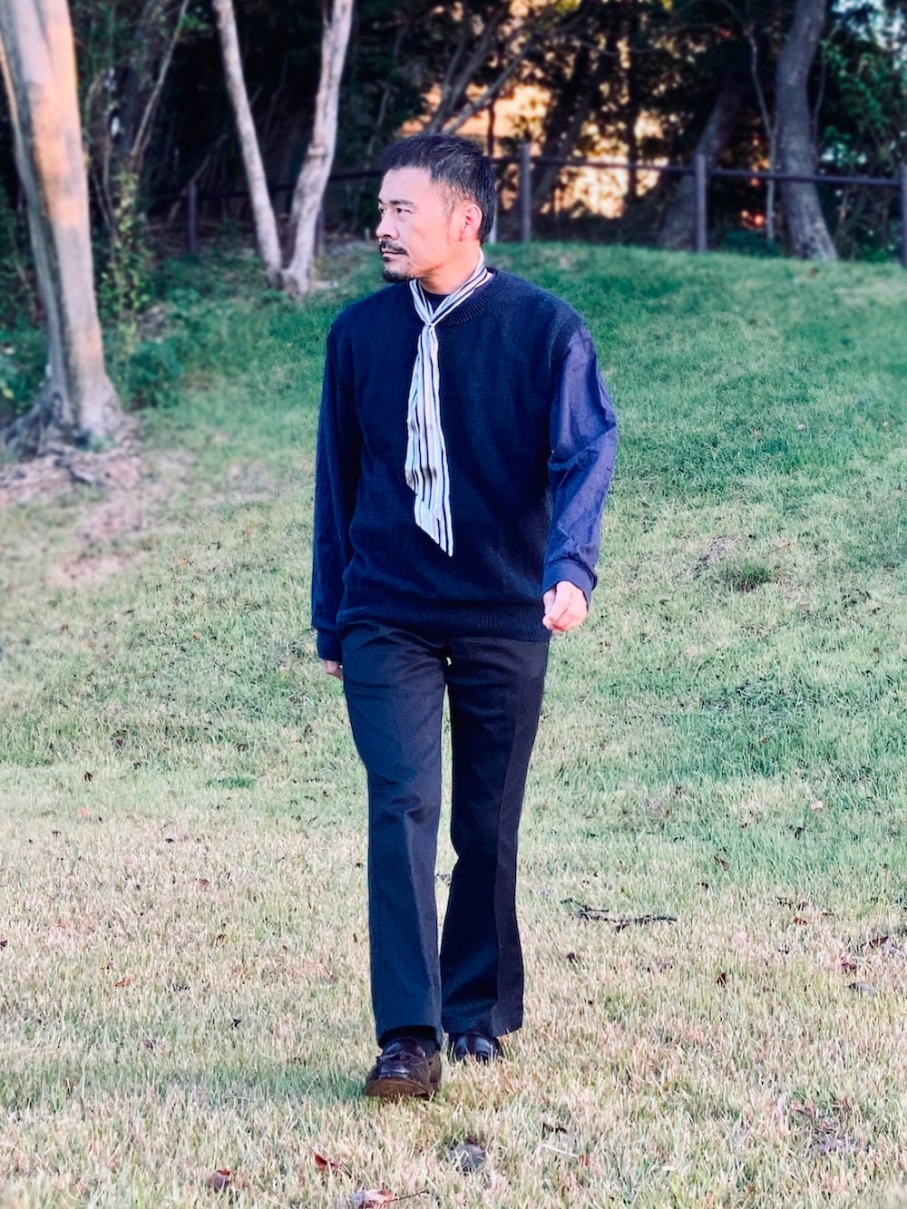 ブルー系のTシャツ/カットソー、ブルー系のベスト、ブルー系のチノパンツを着用したメンズの秋コーディネートの2枚目の写真