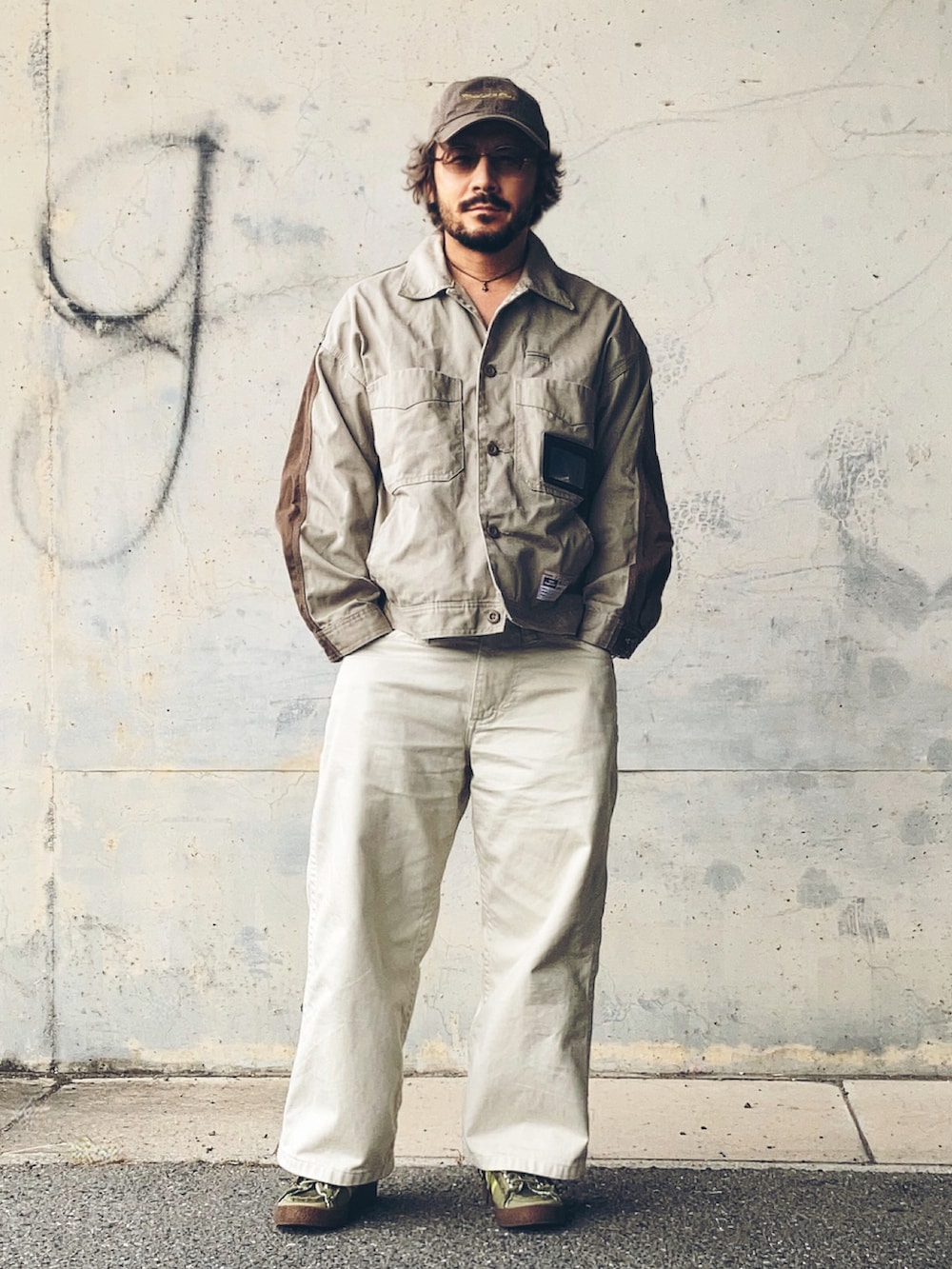 グリーン系のスニーカー、ベージュ系のその他アウター、ホワイト系のデニムパンツを着用したメンズの秋コーディネートの2枚目の写真