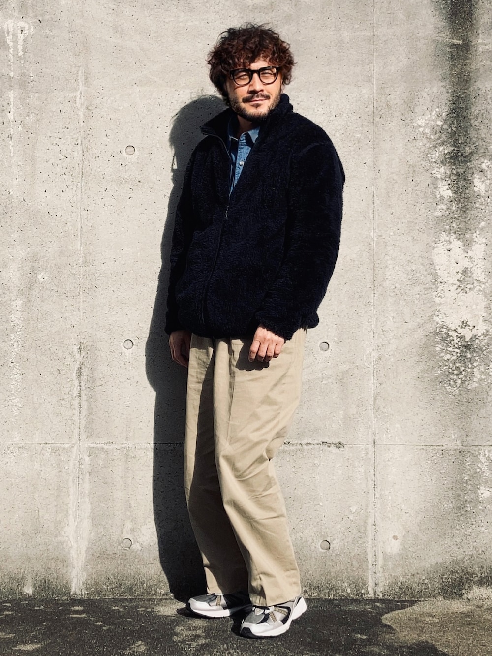 ブラック系のその他アウター、ブルー系のシャツ/ブラウス、ベージュ系のチノパンツを着用したメンズの冬コーディネートの3枚目の写真