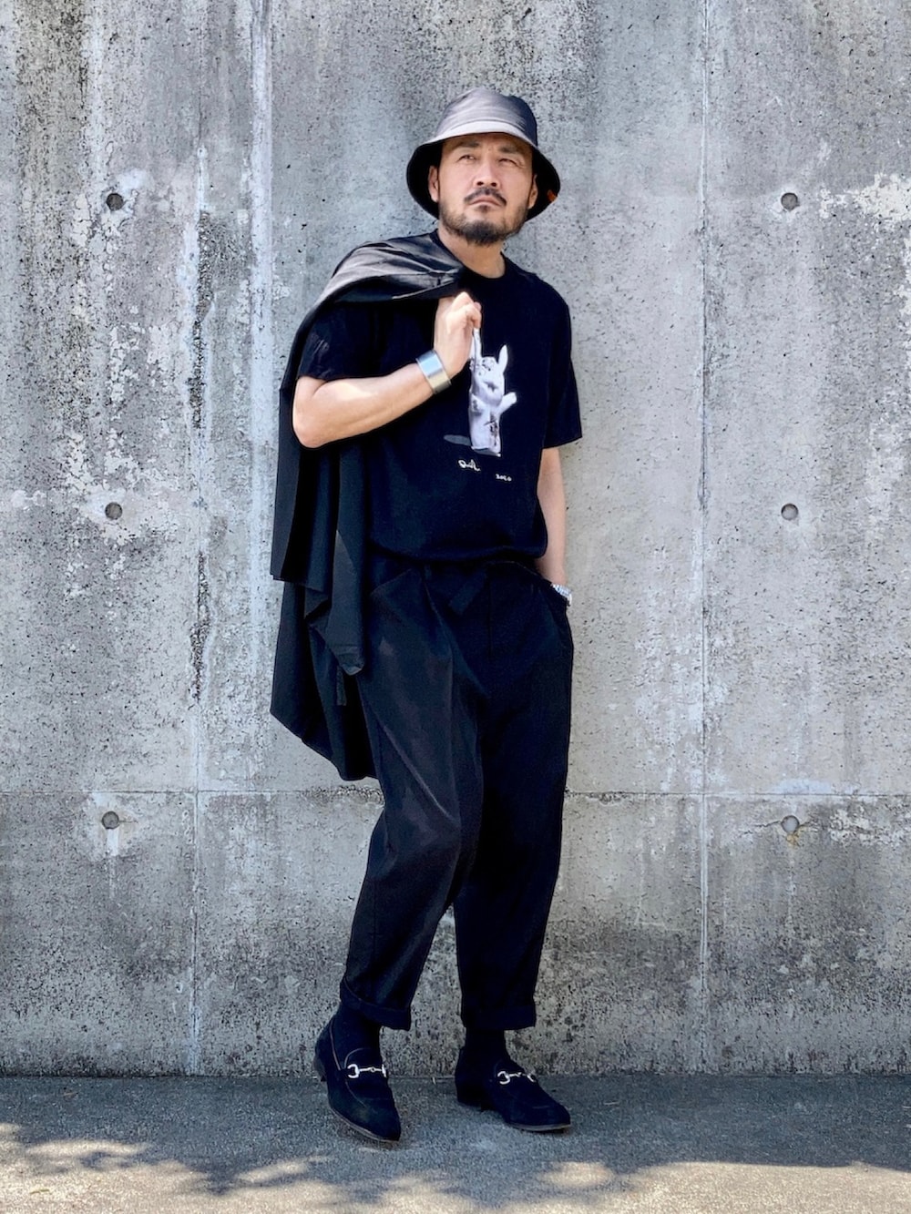 ブラック系のTシャツ/カットソー、ブラック系のスラックス、ブラック系のローファーを着用したメンズの秋コーディネートの3枚目の写真