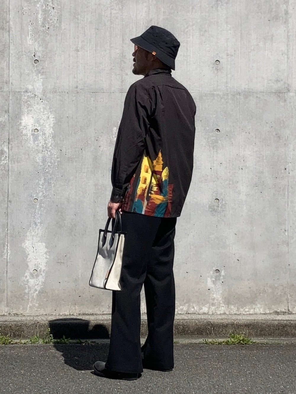 ブラック系のシャツ/ブラウス、ブラック系のスラックス、ブラック系のブーツを着用したメンズの春コーディネートの3枚目の写真