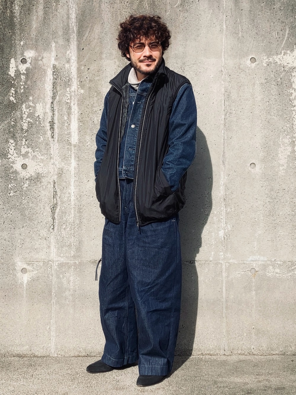 グレー系のTシャツ/カットソー、ブルー系のデニムジャケット、ブラック系のベストを着用したメンズの冬コーディネートの3枚目の写真