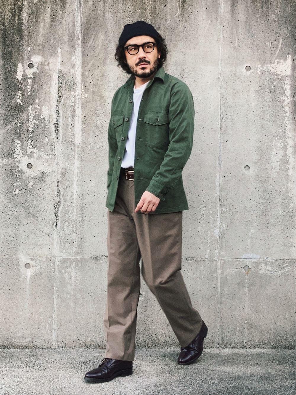 グリーン系のシャツ/ブラウス、ホワイト系のTシャツ/カットソー、ベージュ系のスラックスを着用したメンズの春コーディネートの2枚目の写真