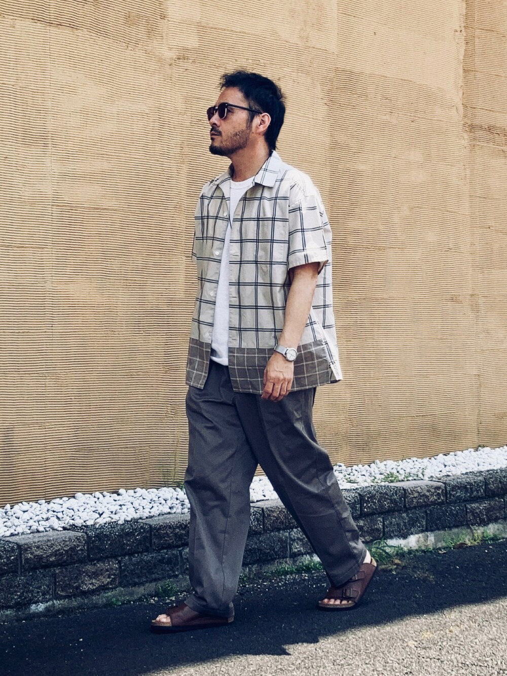 ベージュ系のシャツ/ブラウス、ホワイト系のTシャツ/カットソー、グレー系のスラックスを着用したメンズの春コーディネートの3枚目の写真