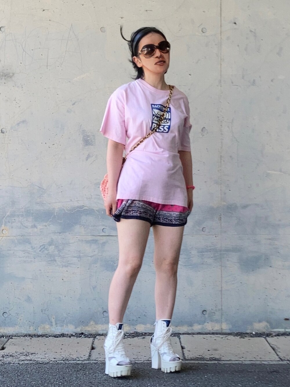 ピンク系のTシャツ/カットソー、ピンク系のショルダーバッグを着用したレディースの夏コーディネートの2枚目の写真
