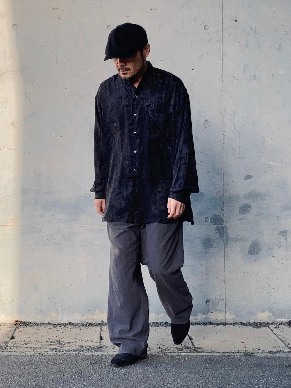 グレー系のスラックス、ブラック系のシャツ/ブラウス、ブラック系のローファーを着用したメンズの春コーディネートの2枚目の写真