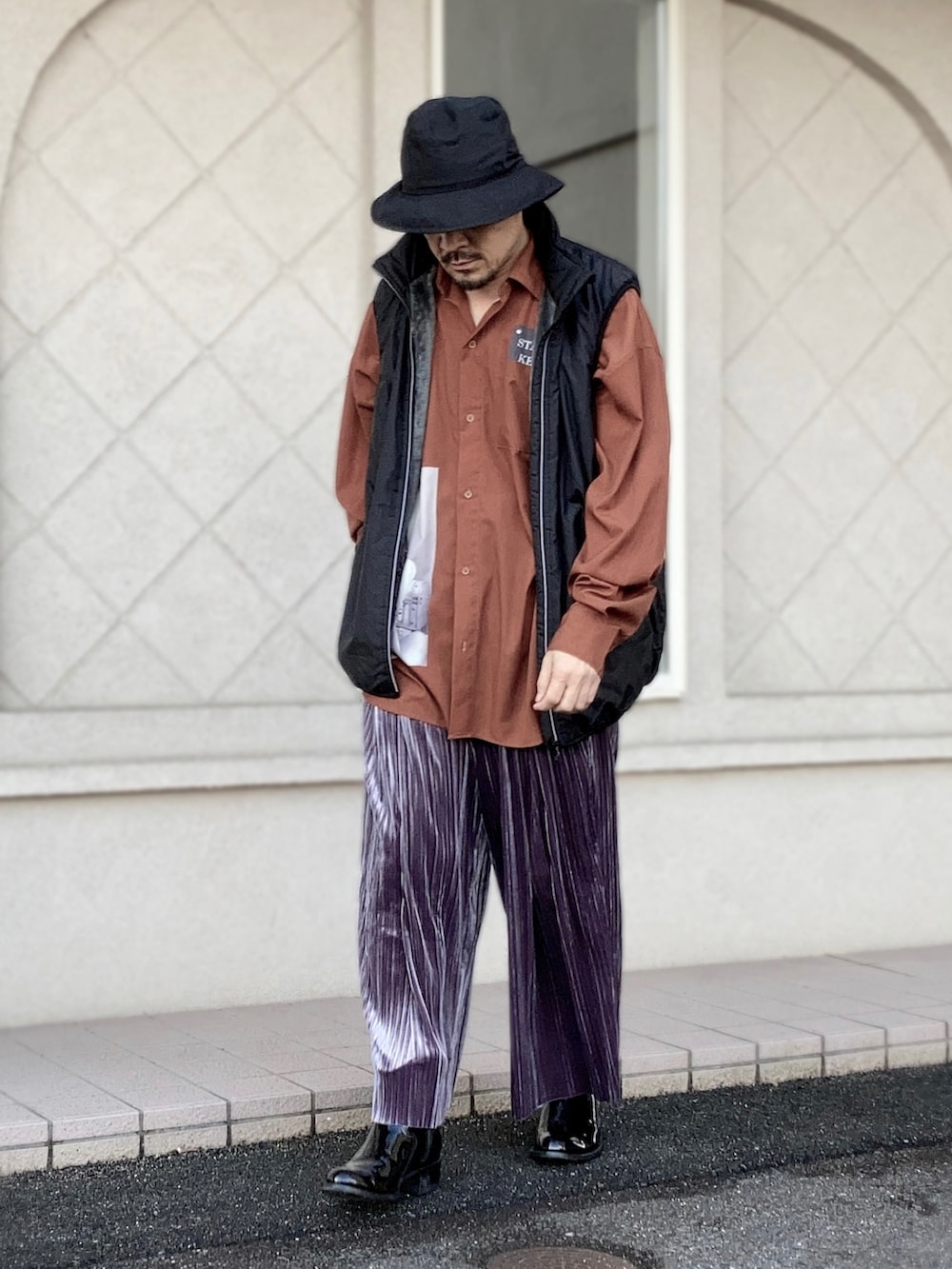 オレンジ系のシャツ/ブラウス、ブラック系のベスト、グレー系のその他パンツを着用したメンズの秋コーディネートの5枚目の写真